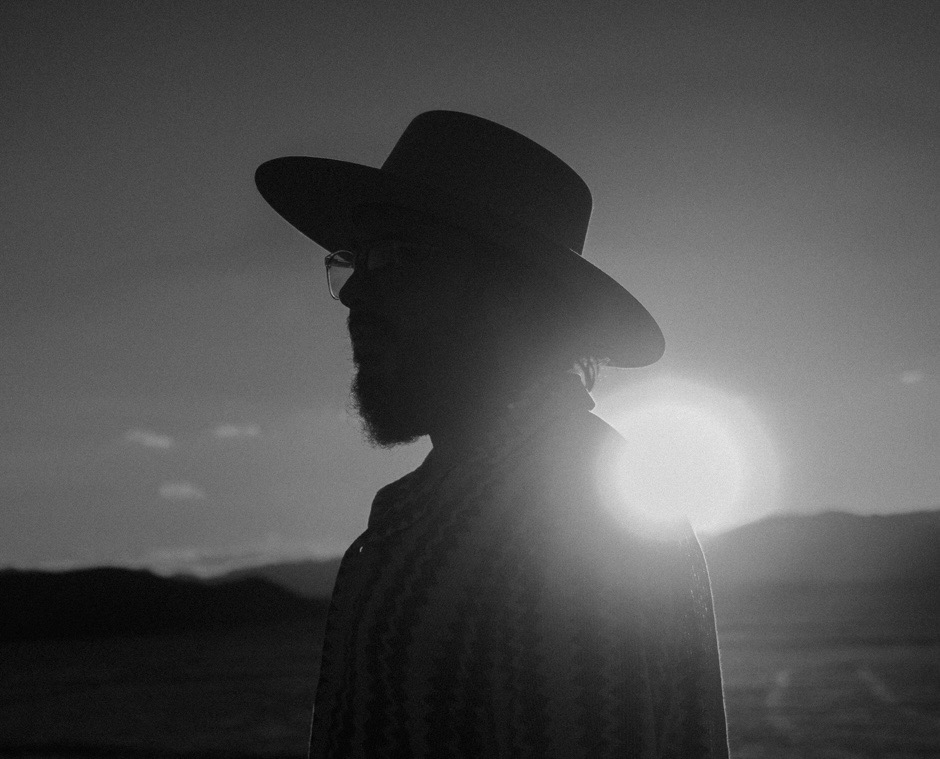 David Rice in profile, silhouetted against sunset in open desert